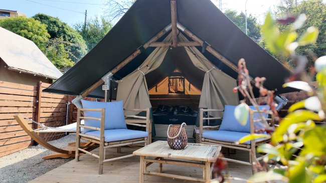 Tenda glamping con sedie e tavolino.
