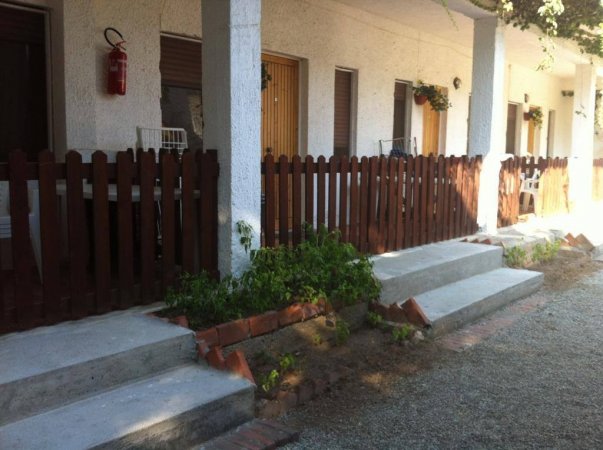 Verande con porte in legno e staccionata marrone.