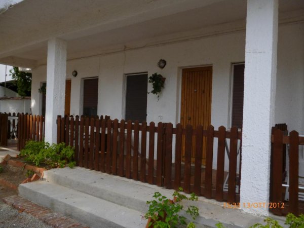 Esterno di un edificio con porte e staccionata di legno.