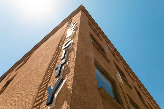 Facciata edificio con scritta su sfondo blu.