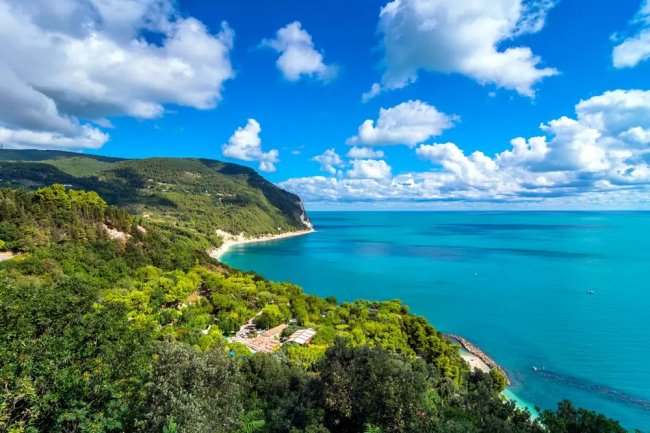 Spiaggia e mare con cielo blu e nuvole.