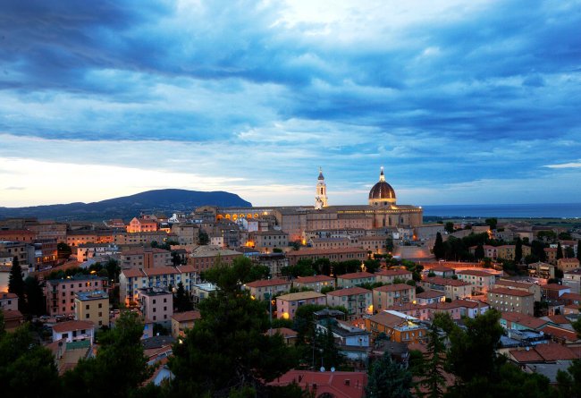Vista panoramica di una città storica sotto un cielo nuvoloso.
