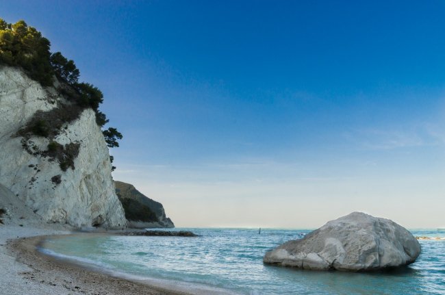 Spiaggia con scogli e mare azzurro.