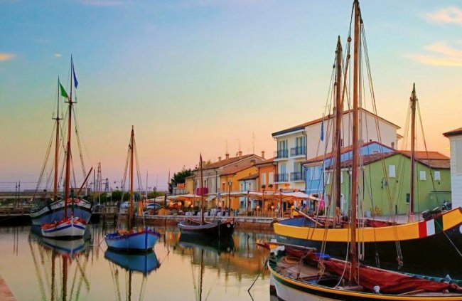 Barche colorate ancorate accanto a edifici.
