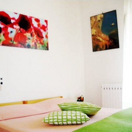 Camera da letto con cuscini verdi e quadri.