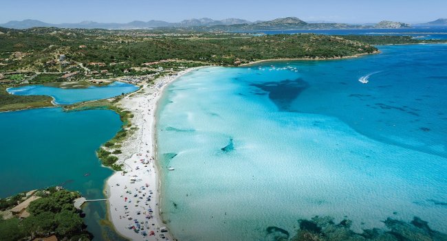 Spiaggia con sabbia bianca e mare turchese vista dall'alto.