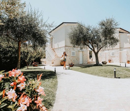 Giardino fiorito con edificio in pietra.