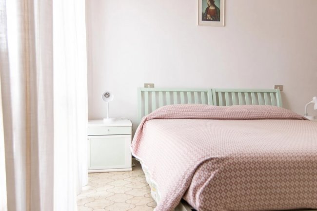 Camera da letto con letto matrimoniale e quadro.