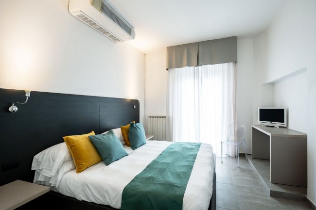 Camera da letto con cuscini colorati.