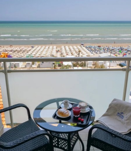 Balcone con tavolino e vista sulla spiaggia.