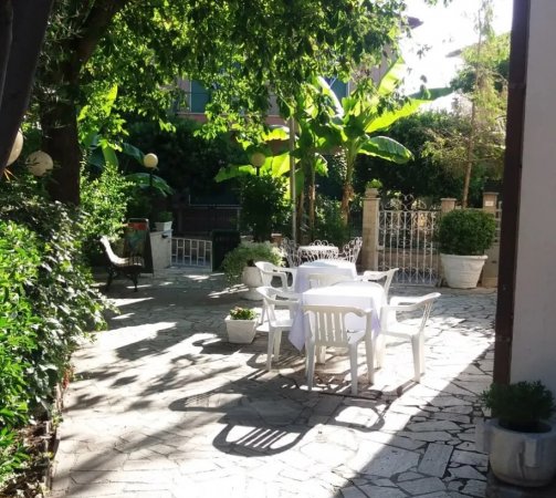 Giardino con tavolo bianco e sedie in plastica.