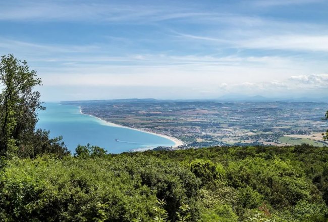 Vista panoramica su costa e mare da una collina.