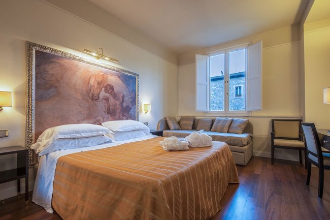 Camera da letto elegante con grande quadro e divano.