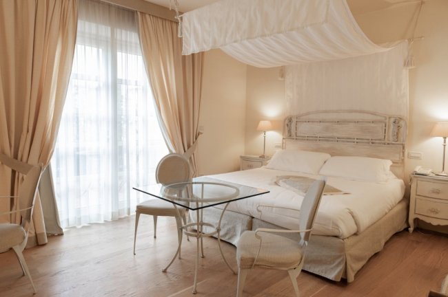 Camera da letto elegante con letto a baldacchino e tende chiare.