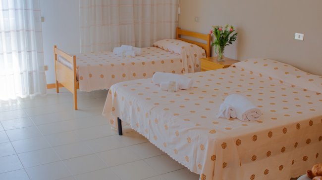 Camera con due letti matrimoniali e teli.