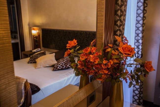 Camera elegante con fiori arancioni sullo specchio.