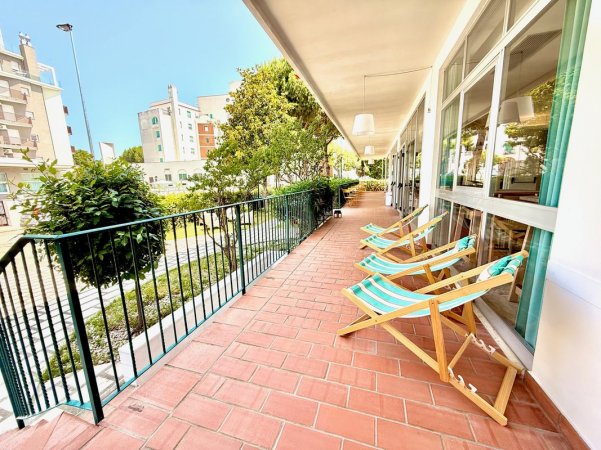 Terrazza con sdraio e vista su giardino urbano.
