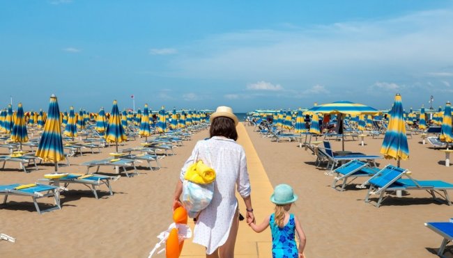 Spiaggia con ombrelloni blu e gialli.
