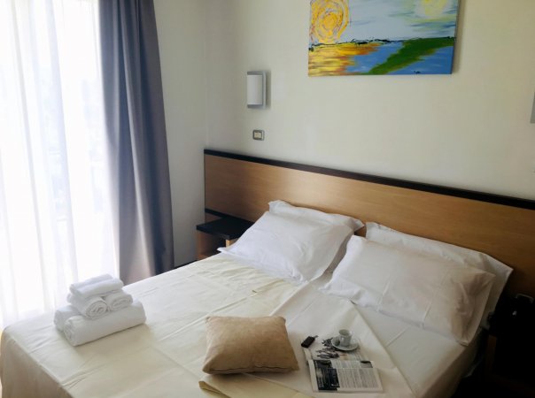 Letto matrimoniale con cuscino e teli.