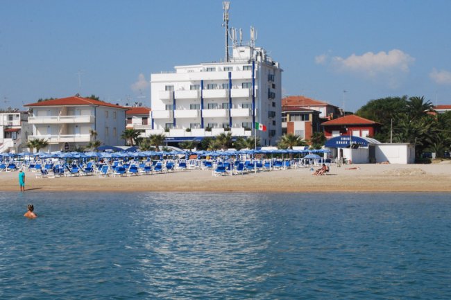Un hotel bianco fronte spiaggia.