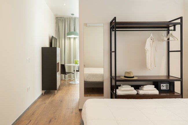 Camera da letto con appendiabiti a vista e specchio.