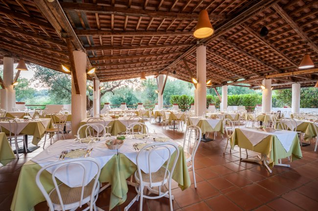 Ristorante all'aperto con tavoli apparecchiati.