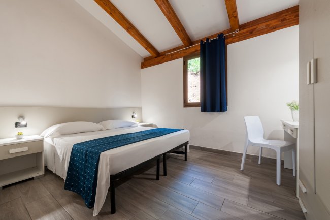 Camera da letto con soffitto in legno e arredi moderni.