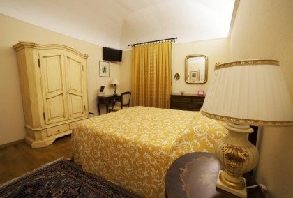 Camera da letto con letto matrimoniale e mobili classici.