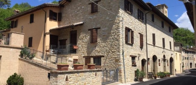 Edificio in pietra su strada soleggiata.