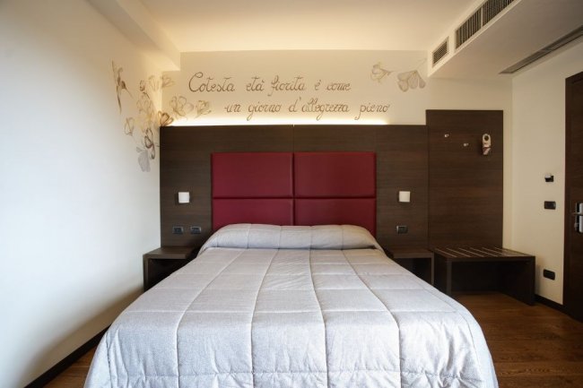 Stanza d'hotel con letto matrimoniale e decorazioni.