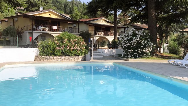 Piscina all'aperto con villette sullo sfondo.