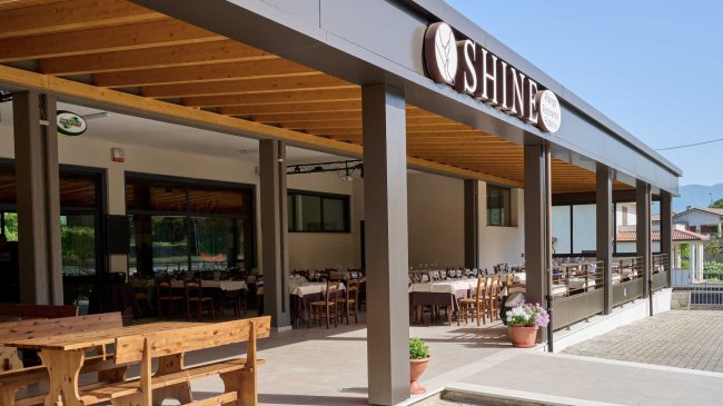 Terrazza esterna di un ristorante con tavoli apparecchiati.