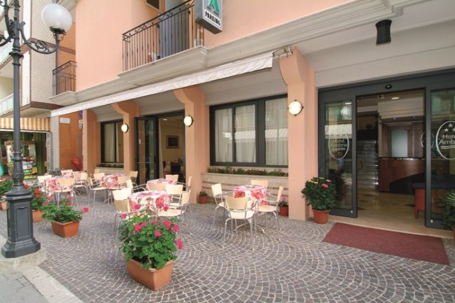 Esterno di un caffè con tavolini e sedie sul marciapiede.