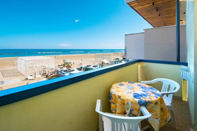 Balcone con tavolo giallo e vista mare.