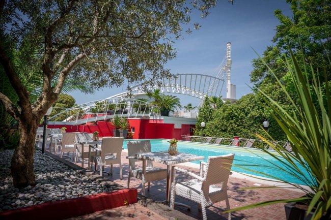 Piscina esterna con sedie bianche e tavoli.