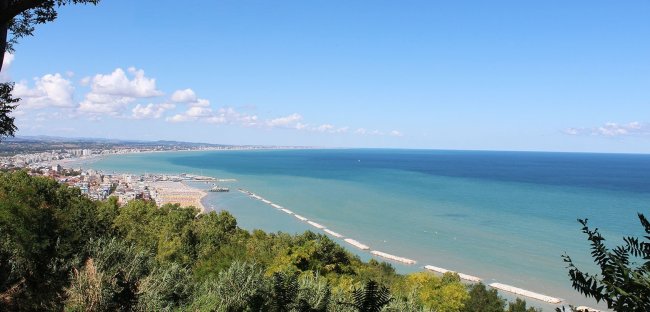 Vista panoramica del mare con spiaggia e città.