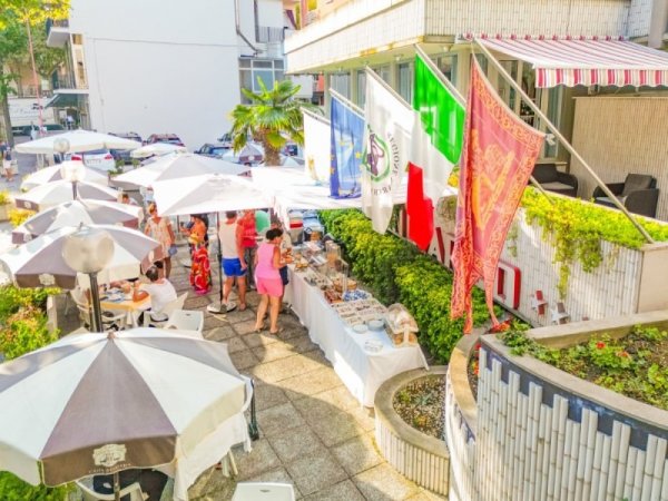 Zona esterna con tavoli, ombrelloni e buffet all'aperto.