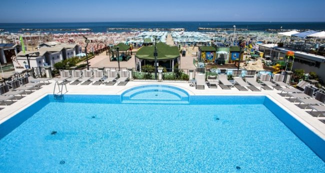 Piscina con ombrelloni e vista sul mare.