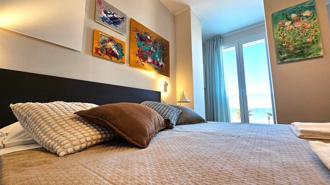 Camera da letto con opere d'arte e vista mare.