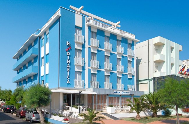 Facciata di un hotel blu a più piani con balconi.