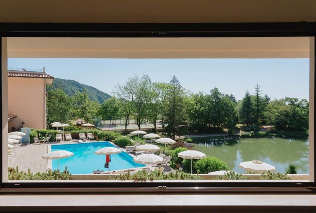 Vista su piscina e giardino dal finestrino.