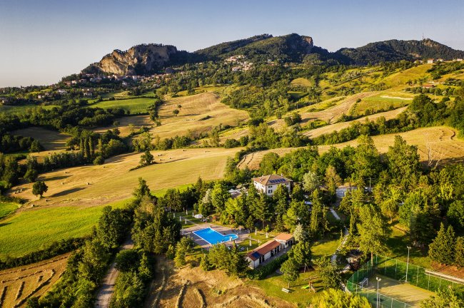 Paesaggio collinare con struttura ricettiva.