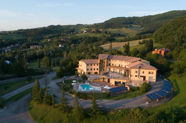 Resort con piscina circondato da colline verdi.