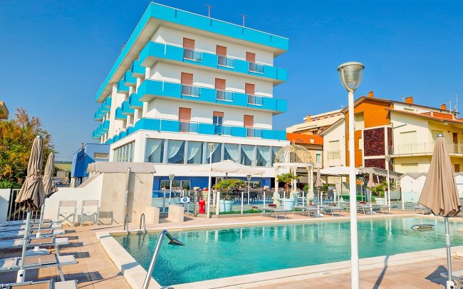 Hotel moderno con piscina e sedie a sdraio.