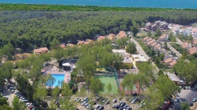 Veduta aerea di un villaggio turistico con piscina e campi sportivi.