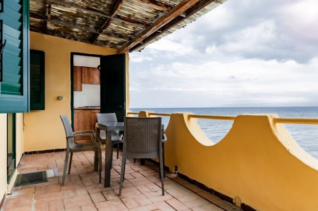 Terrazza vista mare con tavolo e sedie.