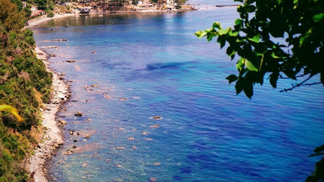 Costa rocciosa con acqua blu cristallina.