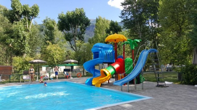 Piscina con scivoli colorati per bambini in un parco acquatico.