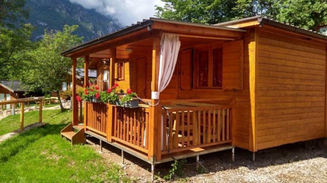 Casetta in legno con veranda fiorita.