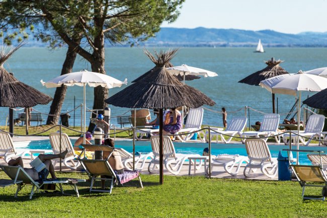 Lettini e ombrelloni vicino a una piscina.